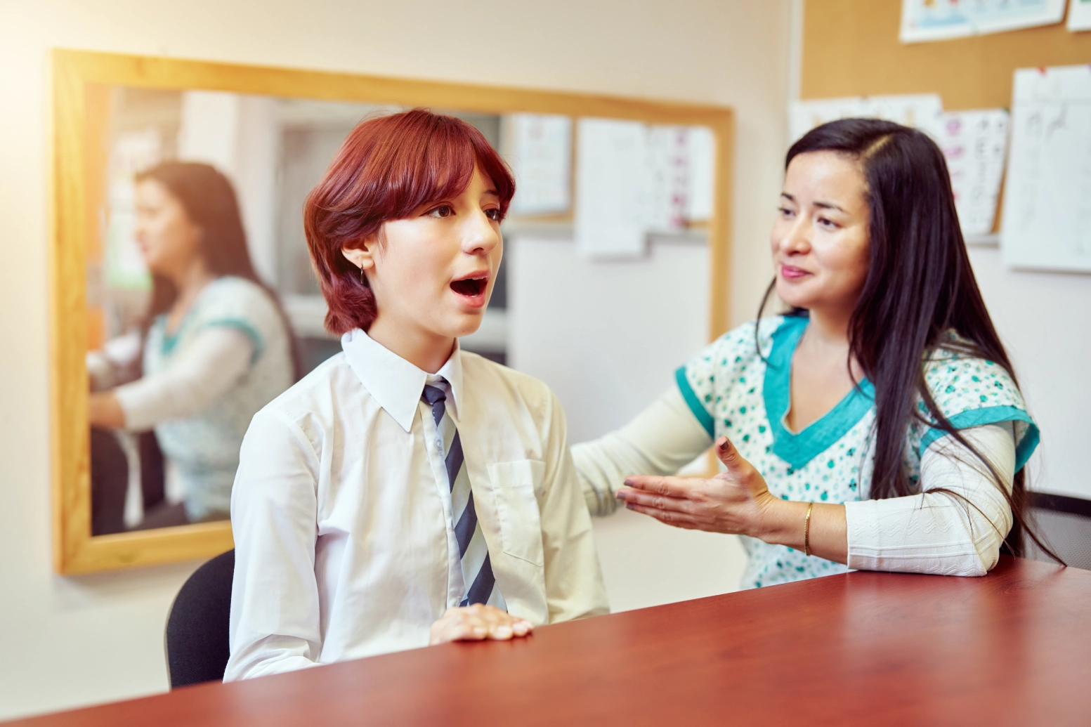 Student practicing speech with teacher.