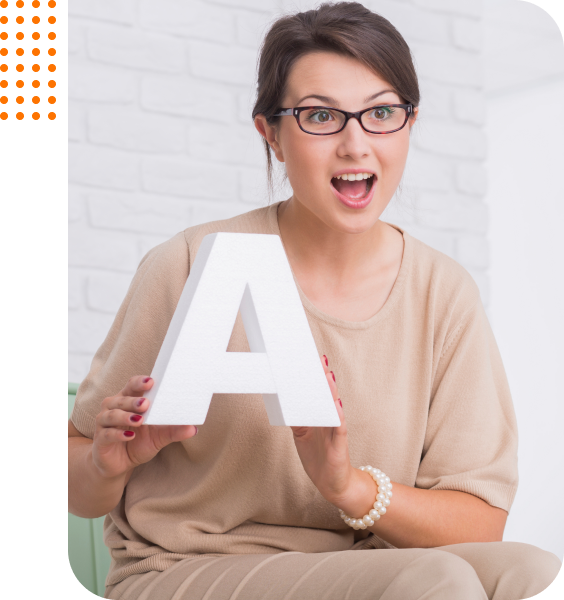 Woman holding letter A, surprised.